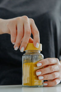 The girl closes the lid on a jar of spices.