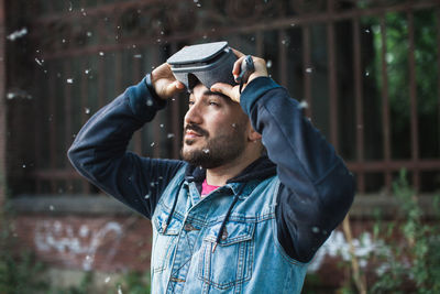 Man wearing virtual reality simulator with cottonwood fluff in mid-air