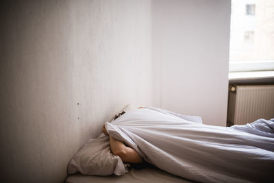 Close-up of person hiding under the sheets