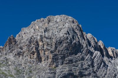 Low angle view of mountain against clear blue sky