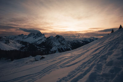 Awesome winter sunset panorama of dolomite hut and mount civetta background