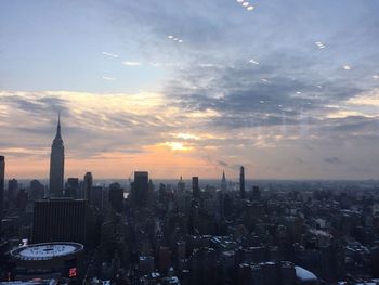 Aerial view of buildings in city at sunset