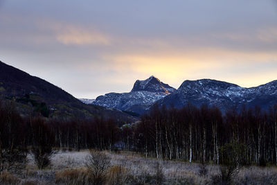 Scenic view of snowcapped mountains against sky at sunset