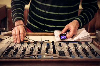 Midsection of man using sound mixer