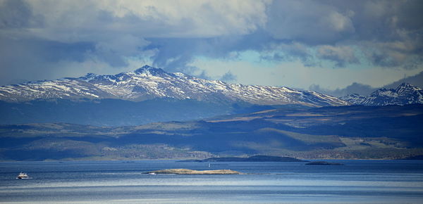 Scenic view of snowcapped mountains by sea against sky