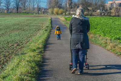 Rear view of women walking on road