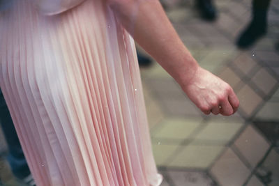 Midsection of woman standing on footpath