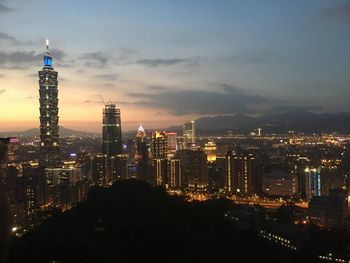 Illuminated cityscape against sky at night