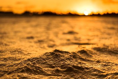 Surface level of sea against sky during sunset