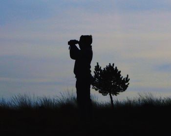 Silhouette of man standing on field