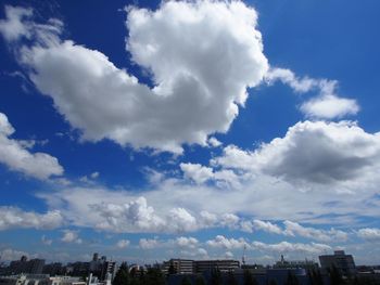 Low angle view of cityscape against blue sky