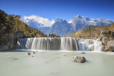 Idyllic waterfall with jade dragon snow mountain in background