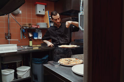 Midsection of man working in kitchen