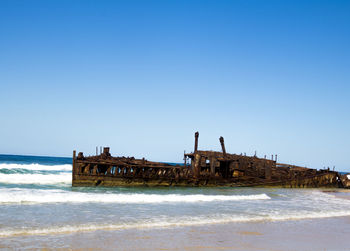 Photograph of the shipwreck of the ss maheno on fraser island with a cloudless sky