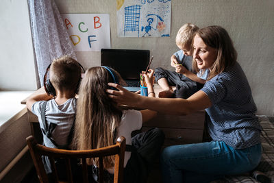 Woman using phone while sitting on table