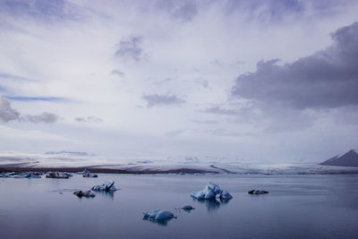 Scenic view of lake against sky during winter