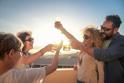 Group of people drinking glass against clear sky