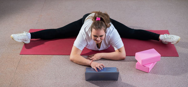 Side view of woman exercising on floor