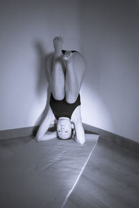 Woman doing yoga on mat at home