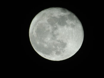 Low angle view of full moon against clear sky at night