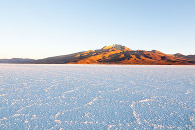 Scenic view of snowcapped mountains against clear blue sky