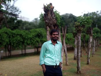 Portrait of man standing against trees