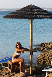 Portrait of young woman sitting at beach