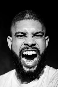 Portrait of young man against black background