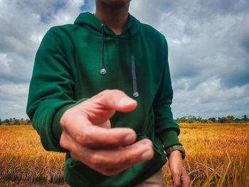 Midsection of man in field against sky