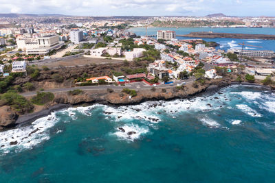 High angle view of townscape by sea against sky