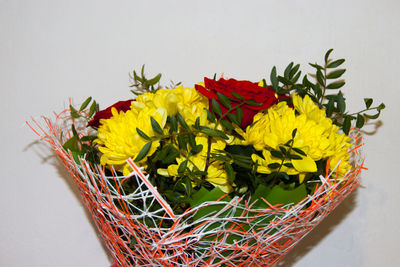 A bouquet of yellow chrysanthemums and red roses in the package stands. flowers