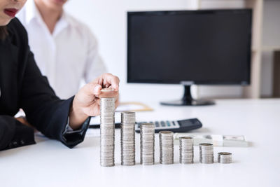 Businessman stacking coins on table