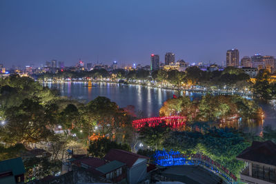 Illuminated cityscape against clear sky at night