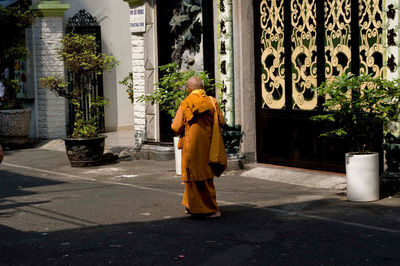 Rear view of woman standing by building