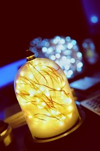 Close-up of illuminated lamp on table