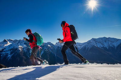 People on snowcapped mountain against sky