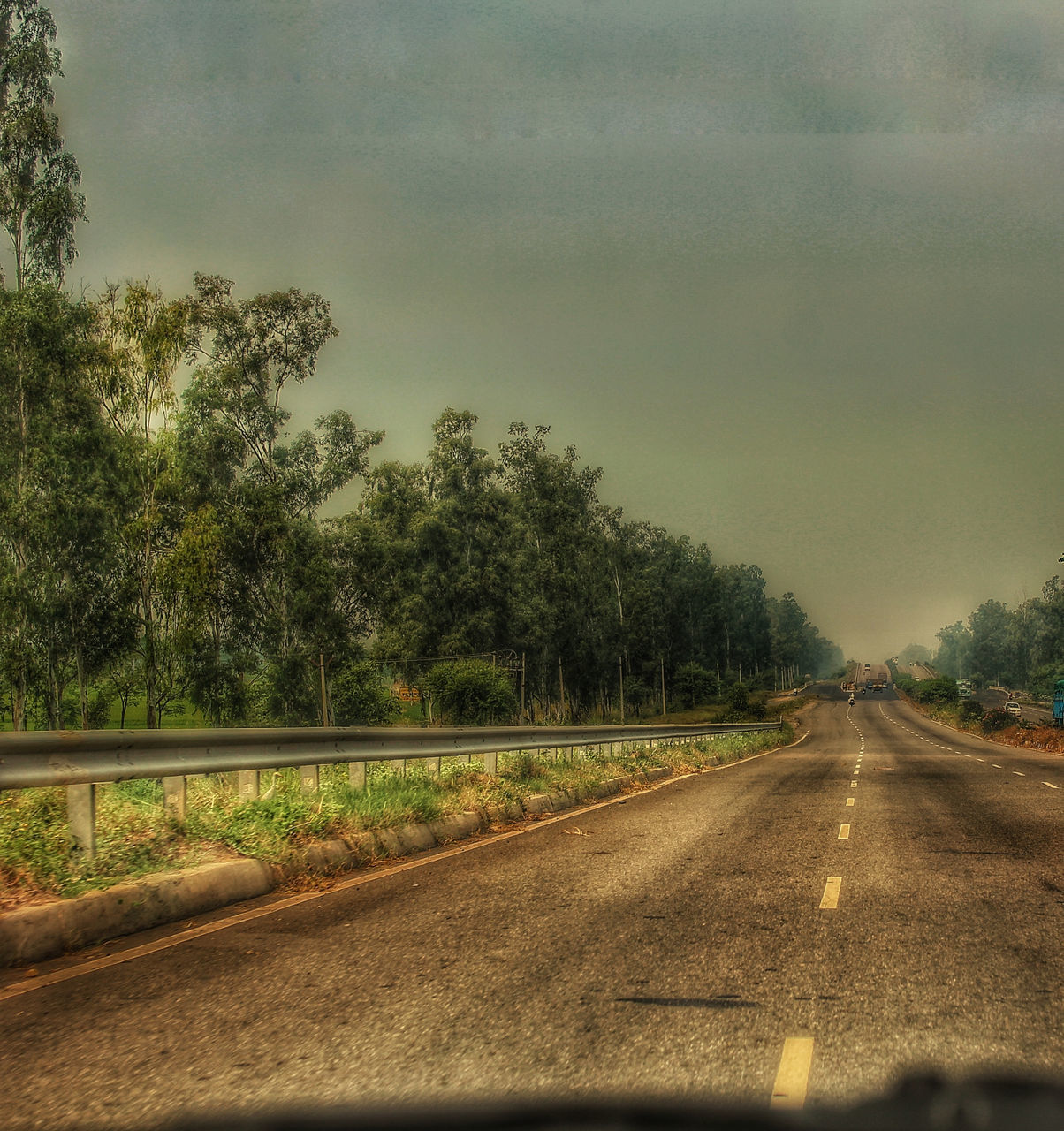 ROAD AMIDST TREES AGAINST SKY SEEN THROUGH WINDSHIELD