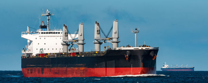 Sailboat on pier by sea against sky