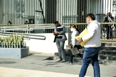 Side view of a young man standing in city