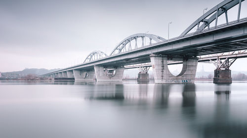 Low angle view of bridge over river against sky in city