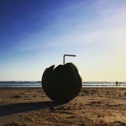 Close-up of crystal ball on beach against clear sky