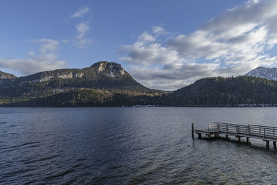 Scenic view of lake by mountains against sky