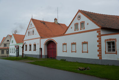 Houses by street against sky in city