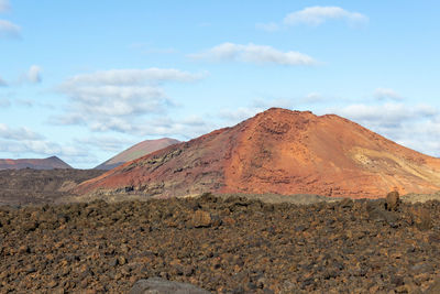 Volcanic landscape with lava field in the foreground and mountain range with different colours