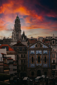 Buildings in city against sky during sunset