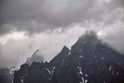 Low angle view of snowcapped mountains against sky