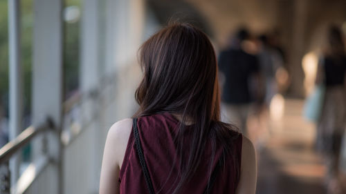 Rear view of woman standing by window