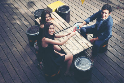 Portrait of happy friends toasting drinks at bar