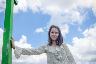 Portrait of woman standing against sky