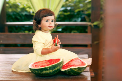 Girl eating watermelon on table